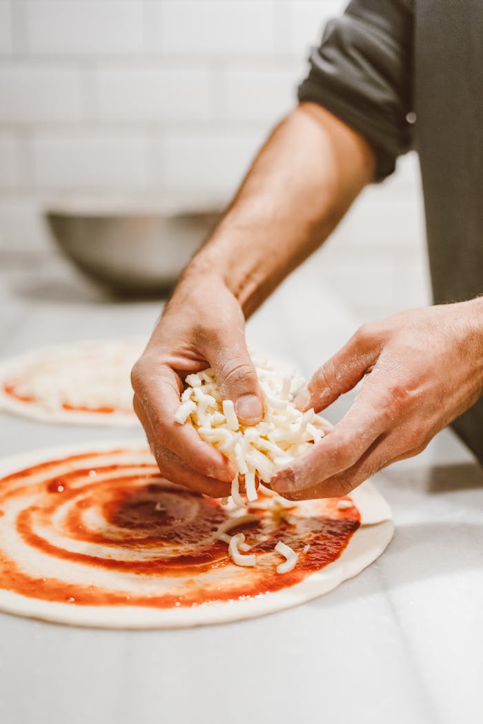 Pizzaiolo che prepara una pizza artigianale con ingredienti freschi italiani in pizzeria